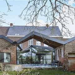 A Glass-Wrapped Living Space Cracks Open a Historic Brick Home in Belgium