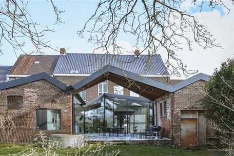 A Glass-Wrapped Living Space Cracks Open a Historic Brick Home in Belgium